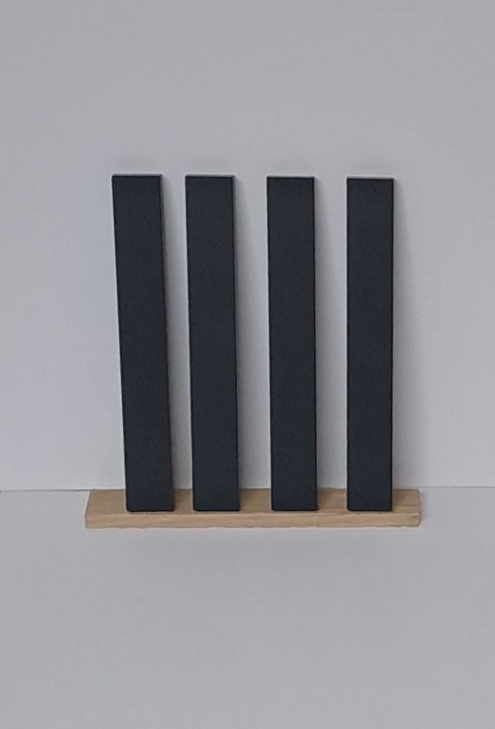 Die vier Anthrazit Easy-Sticks von Easy-Sticks, unter einem stilvollen Holzrahmen angeordnet. Vielseitig einsetzbar für individuelle Projekte.