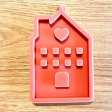 Eine hochwertige Silikonform von Easy-Sticks in Form eines Hauses mit Herz, ideal zum Gießen von Kerzen oder anderen kreativen Projekten. Perfekt für DIY-Enthusiasten.