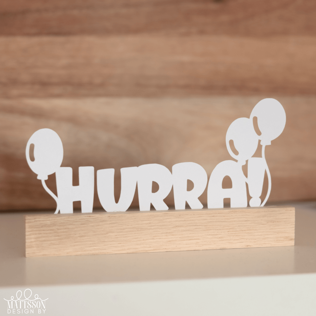 Weiße HURRA Dekoration mit Luftballons auf einem Holzständer, ideal für kreative Geschenke und DIY-Projekte von easy-sticks.