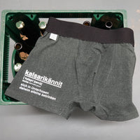 Funky Kalsarikännit Stil von easy-sticks: Eine Boxershorts auf einem Kasten mit Flaschen, verziert mit dem Schriftzug "kalsarikännit" für kreative und lustige Bastelprojekte.