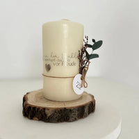 Elegante, cremefarbene Stumpfkerze auf einer Holzscheibe, liebevoll dekoriert mit Zweigen und einem Anhänger, perfekt für persönliche Geschenke. Kerzentattoo Metallic Wasserschiebefolie Geburtstag von easy-sticks.