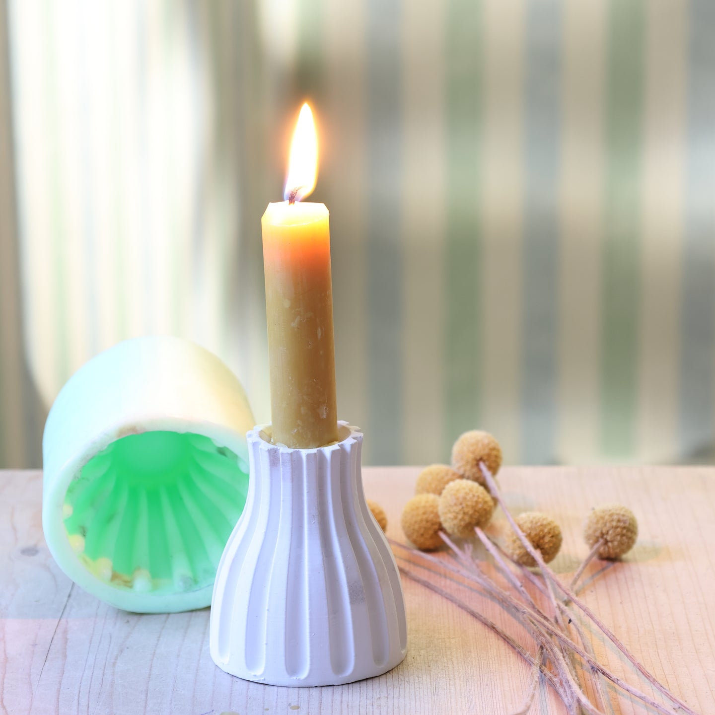 Gestreifter Kerzen-Ständer von easy-sticks mit einer flammenbewehrten Kerze in einem dekorativ gestalteten Raum. Die Silikonform zeigt ihre Vielseitigkeit und modernes Design.