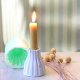 Gestreifter Kerzen-Ständer von easy-sticks mit einer flammenbewehrten Kerze in einem dekorativ gestalteten Raum. Die Silikonform zeigt ihre Vielseitigkeit und modernes Design.
