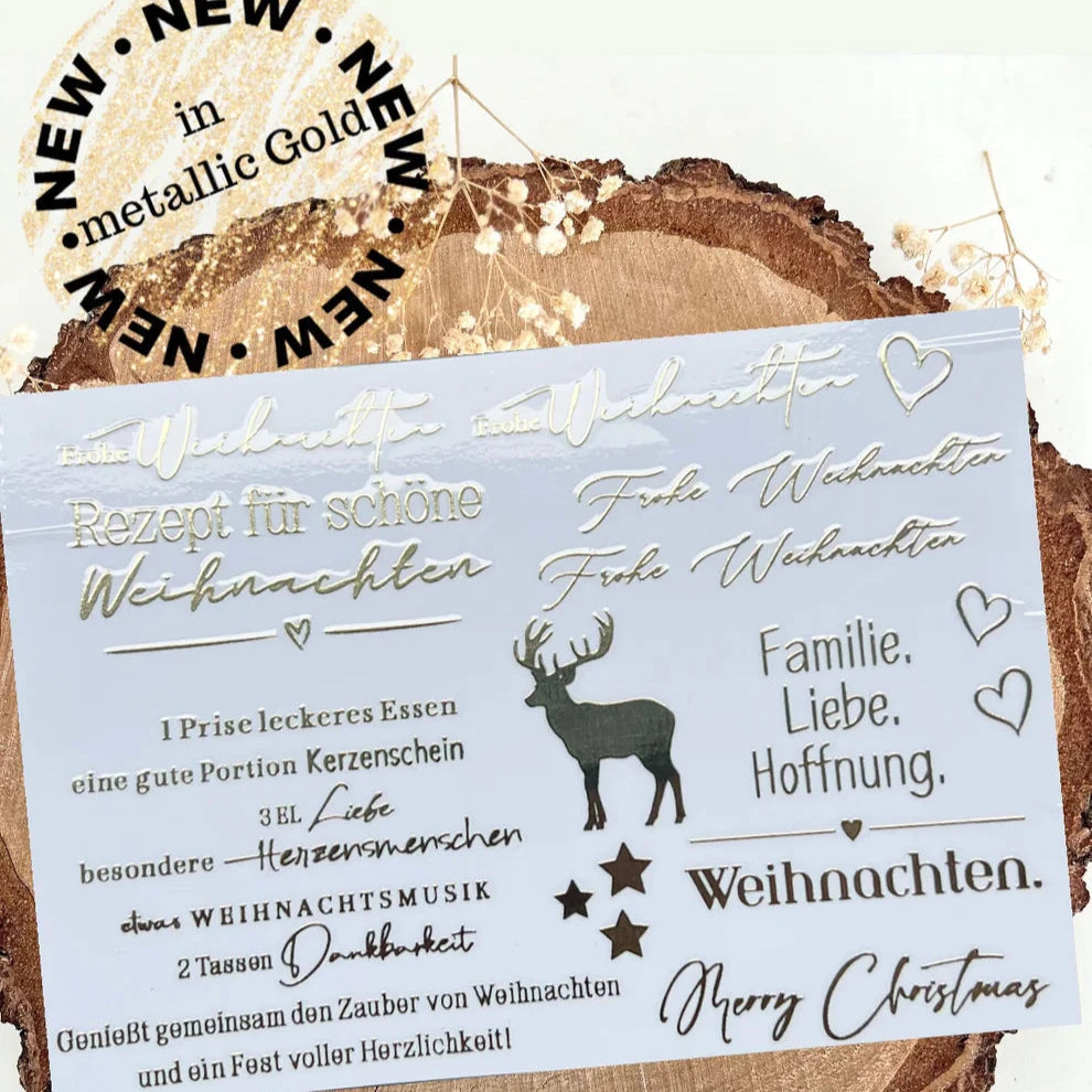 Goldene Weihnachtsaufkleber Rub On UV Sticker Randlos A5 von easy-sticks, mit festlichen Motiven wie 'Frohe Weihnachten' und einem Rentier, metallisch glänzend auf abgerundetem Holzuntergrund.
