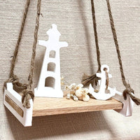 Schaukelbank von Easy-Sticks mit maritimen Dekorationselementen wie einem Leuchtturm und einem Anker, perfekt für kreative Bastelprojekte.