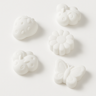 Weiße Formen in Schmetterlings-, Marienkäfer- und Blumen-Design, aus der Silikonform von Easy-Sticks - perfekt für Backen und Dekorieren.