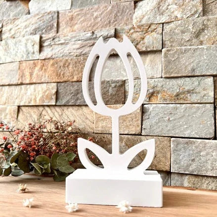 Kreativer Silikonform Einschieber - Tulpe von Easy-Sticks, dargestellt als schlanke, moderne Blumenskulptur auf einem rustikalen Steinboden mit floralen Dekorationselementen.