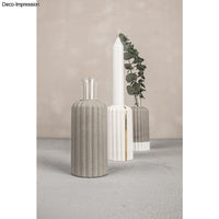 Designbeispiel der Silikonform "Vase geriffelt" von Easy-Sticks, präsentiert mehrere stilvolle Vasen aus Kreativ-Beton und einer dekorativen Pflanze.