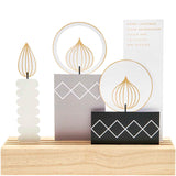 Kreatives Postkartendeko-Set Kerzen von easy-sticks, bestehend aus vier eleganten Kerzen mit einem modernen Design auf einem hölzernen Untergrund.