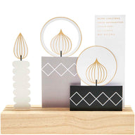 Kreatives Postkartendeko-Set Kerzen von easy-sticks, bestehend aus vier eleganten Kerzen mit einem modernen Design auf einem hölzernen Untergrund.