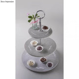 Metall Etageren Bausatz Classic von easy-sticks, präsentiert in einem stilvollen, drei-stufigen Design mit köstlichen Muffins und Pralinen, dekoriert mit einer kleinen Blumenvase.