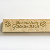 Detailaufnahme eines Holzstickers 'Herzlichen Glückwunsch' in gold, designt von easy-sticks.