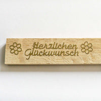 Detailaufnahme eines Holzstickers 'Herzlichen Glückwunsch' in gold, designt von easy-sticks.