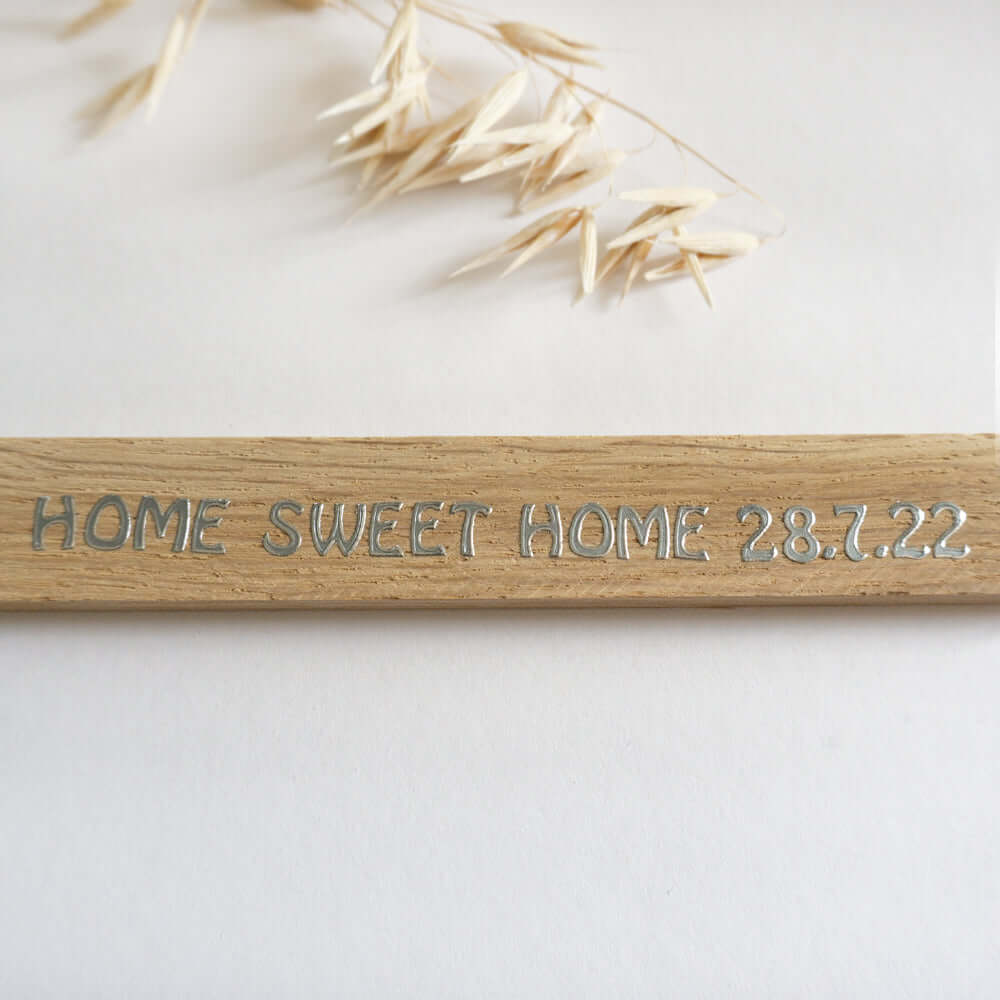Nahaufnahme eines Holzschildes mit dem Schriftzug 'Home Sweet Home 28.7.22' von easy-sticks, ideal für Dekoration und Geschenke.