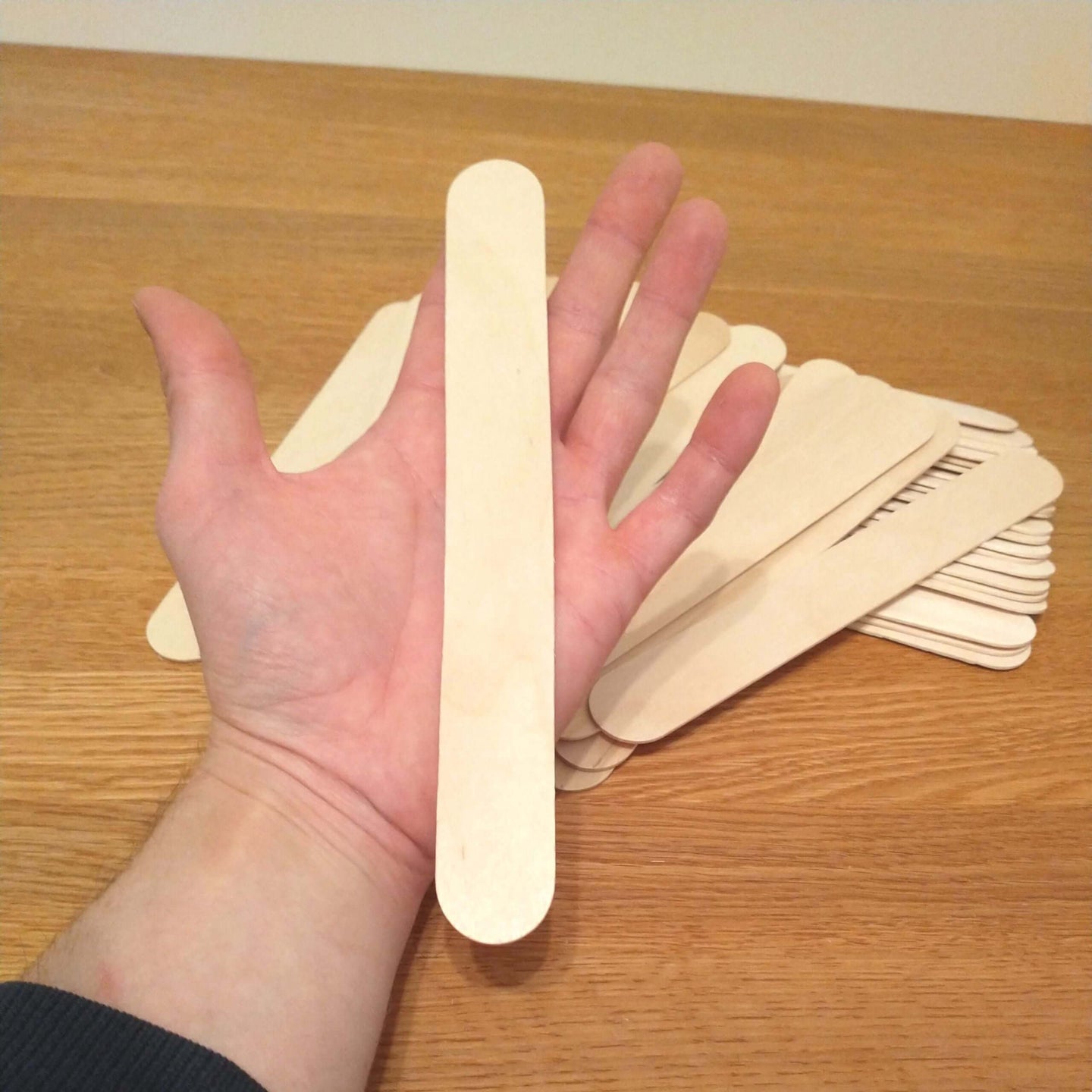 Hand hält einen Easy-Sticks Ice Holzstab von 20 cm Länge – Ideal zum Basteln mit Easy-Sticks für kreative Projekte.