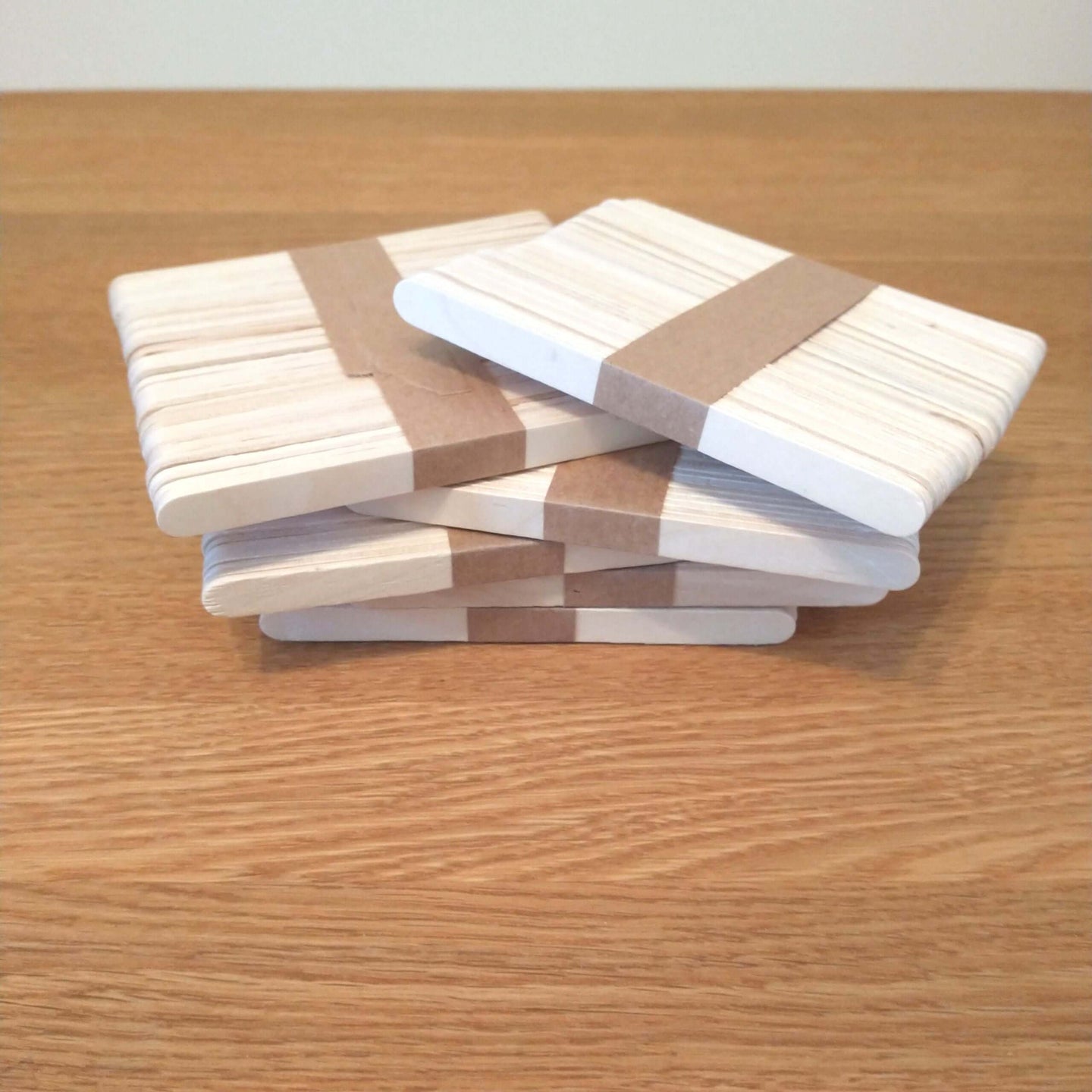 Die Verpackung von Easy-Sticks Ice von Easy-Sticks: Mehrere Stapel dünner Holzstäbchen, perfekt für Bastelideen, geordnet auf einem Holztisch.