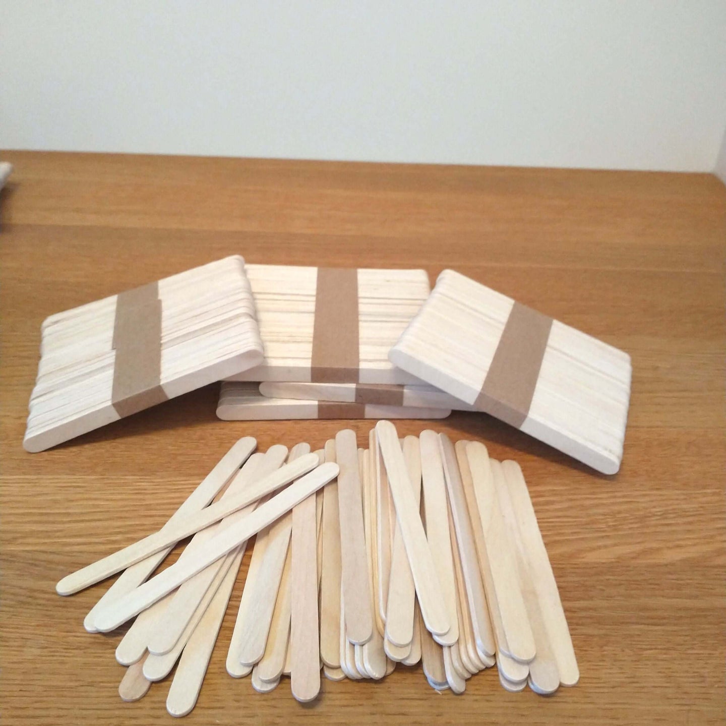 Easy-Sticks Ice von Easy-Sticks: Ein Set aus 100 dünnen Holzstäbchen mit einer Länge von 6,5 cm, ideal für kreative Bastelprojekte, auf einem Holztisch angeordnet.
