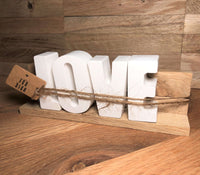 Dekoration Set von easy-sticks: liebevoll gestaltete LOVE Buchstaben auf natürlicher Holzleiste, perfekt als Geschenk mit einem süßen Geschenkanhänger.
