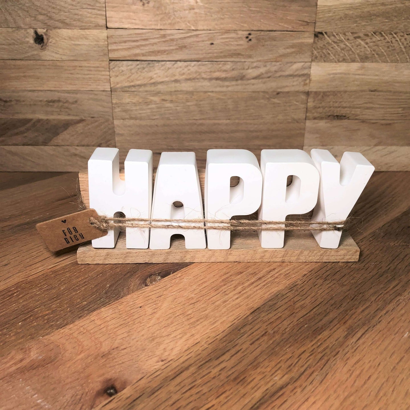 Handgemachte HAPPY Dekoleiste von easy-sticks, weiße Buchstaben, die das Wort 'HAPPY' bilden, auf einem Holzstand, ideal als kreative Deko und Geschenkidee zum Einzug oder Geburtstag.