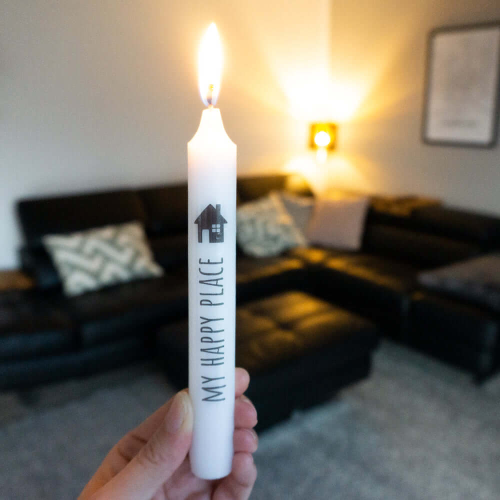 Person hält eine Weihnachtskerze mit dem Aufdruck 'MY HAPPY PLACE', ideal für festliche Dekoration, von easy-sticks, Weihnachtskerzen Sticker PDF Download für Stabkerzen mit festlichen Motiven.