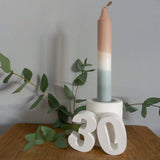 Handgemachte Zahlen 30 aus Keraflott präsentiert neben einer stilvollen Kerze und Eukalyptus, ideale Deko von easy-sticks für dein Zuhause oder als Geschenk.