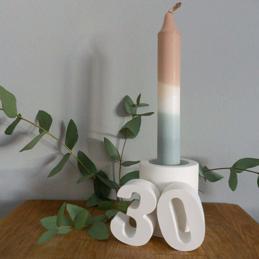 Handgemachte Zahlen 30 aus Keraflott präsentiert neben einer stilvollen Kerze und Eukalyptus, ideale Deko von easy-sticks für dein Zuhause oder als Geschenk.