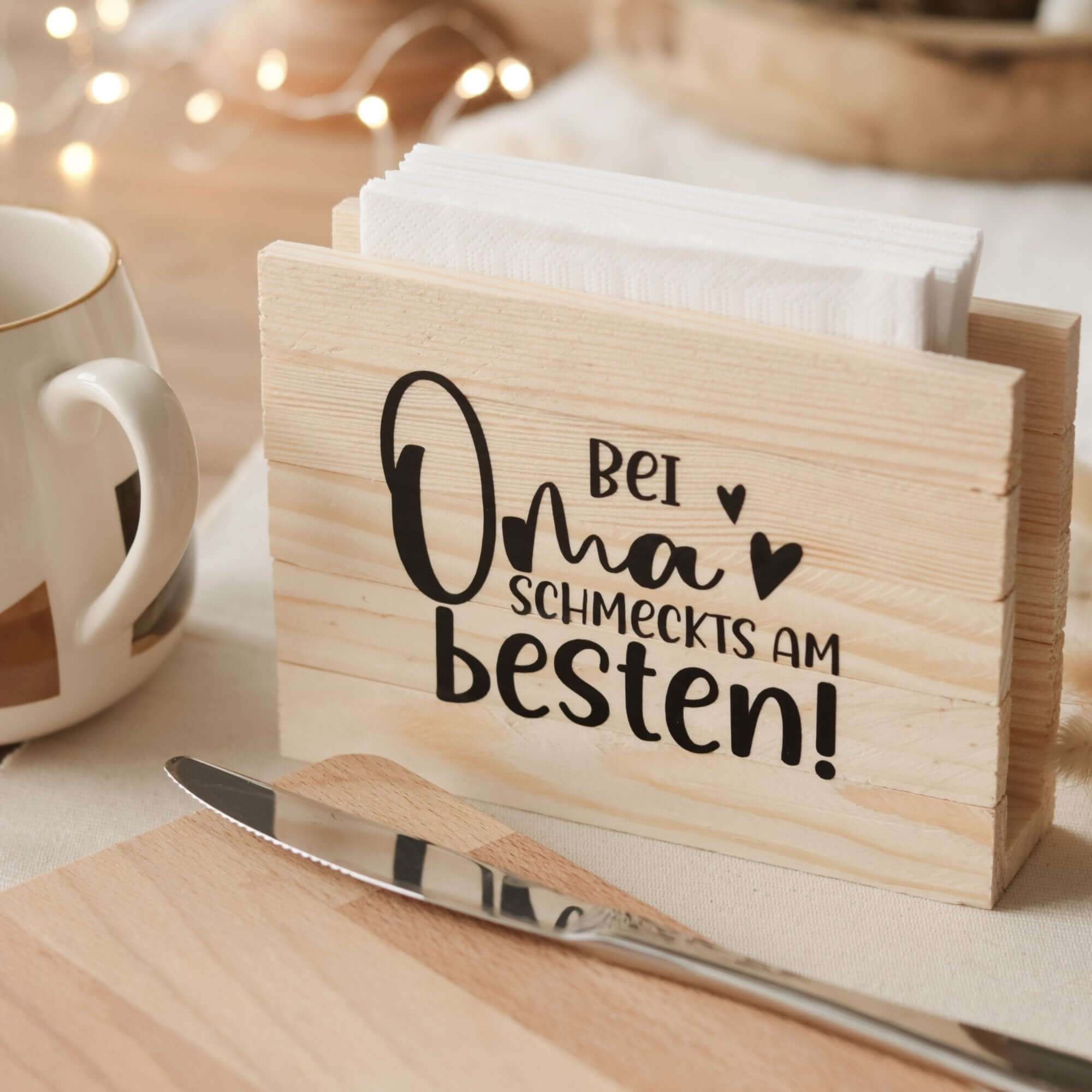 Schöner Holz Serviettenhalter, beschriftet mit 'Bei Oma schmeckts am besten!', hergestellt mit der Plotterdatei von easy-sticks – perfektes DIY für festliche Anlässe.