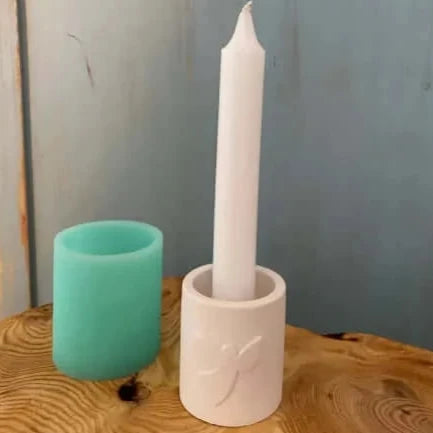 Silikonform von Easy-Sticks für Stabkerze und Teelichthalter mit einem Engel, zeigt eine helle Teelichthalterform und eine weiße Stabkerze.
