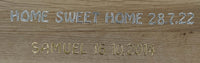 Holzplatte mit eingravierten Buchstaben "HOME SWEET HOME 28.7.22" und "SAMUEL 16.10.2014" in Silber und Gold von easy-sticks.