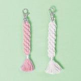 Zwei kreativ geflochtene Makramee-Anhänger in Rosa und Creme von easy-sticks, perfekt für DIY-Projekte mit dem Baumwollgarn für Makramee.