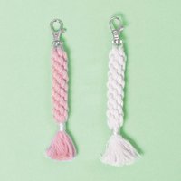 Zwei kreativ geflochtene Makramee-Anhänger in Rosa und Creme von easy-sticks, perfekt für DIY-Projekte mit dem Baumwollgarn für Makramee.